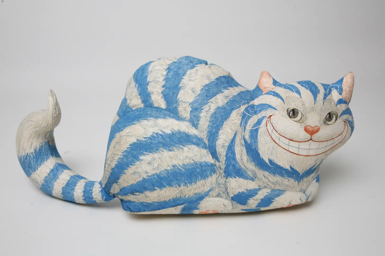John Tenniel's Cheshire Cat grinning down from a tree branch